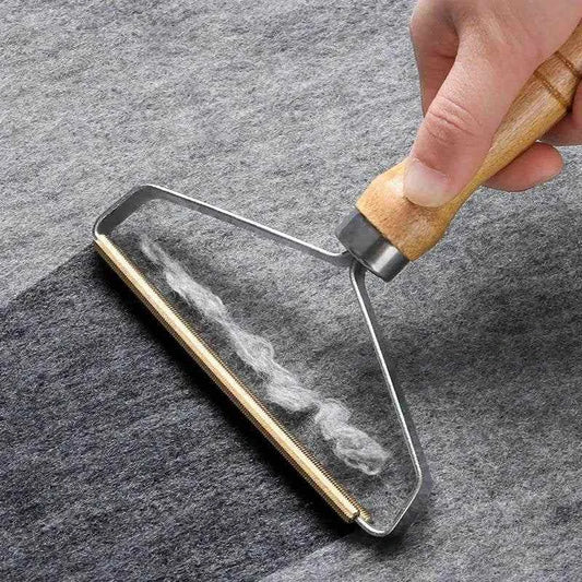 Pet Hair Remover Brush with wooden handle removing pet hair from gray fabric surface